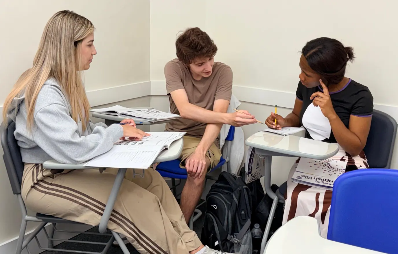 Three MILA students working together in class